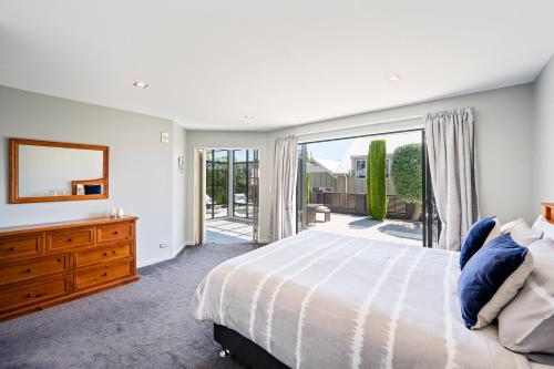 a bedroom with a large bed and a large window at IRONSIDE LAKEVIEW TOWNHOUSE in Wanaka