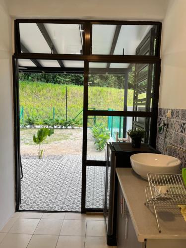 a bathroom with a sink and a large glass door at Tun Teja Homestay Jasin Melaka in Jasin