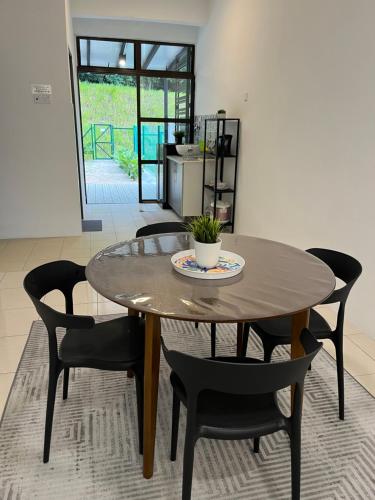 a dining room table with black chairs and a table at Tun Teja Homestay Jasin Melaka in Jasin