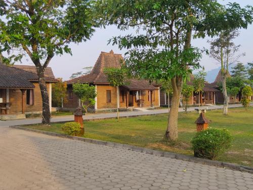 a row of houses with trees and a street at Balkondes Wanurejo in Borobudur