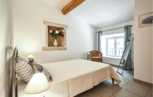 - une chambre avec un lit et un vase de fleurs dans l'établissement 2 Bedroom Pet Friendly Home In Montbrison-sur-lez, à Montbrison-sur-Lez
