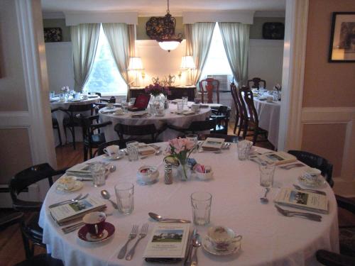 a dining room with tables with white tablecloths and chairs at Victoria Inn in Hampton