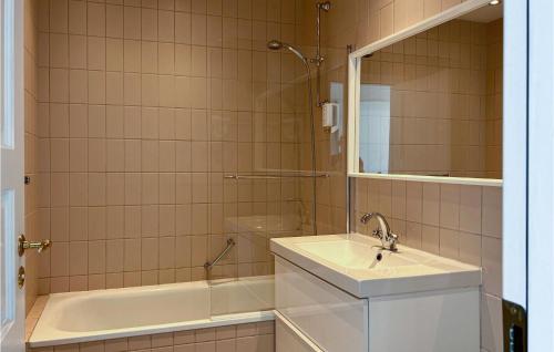 a bathroom with a sink and a tub and a mirror at Beautiful Apartment In Helsingr With Wifi in Helsingør