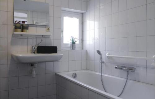 een badkamer met een wastafel, een bad en een wastafel bij Gentiaan in Ommen