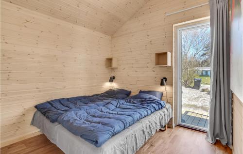 duże łóżko w drewnianym pokoju z oknem w obiekcie Pet Friendly Home In Sejer With Wifi w mieście Sejerby