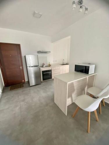 cocina blanca con encimera y nevera en Sandstone Apartment a walk to the beach, en Flic en Flac