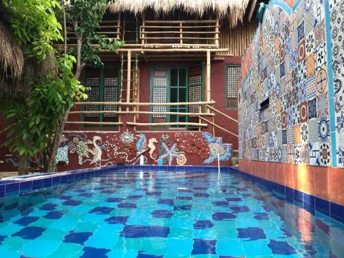 a swimming pool in front of a building with a tile wall at Capiz Beach Villa family room for 6 pax in Calatagan