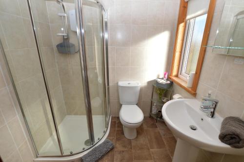 a bathroom with a shower and a toilet and a sink at Holy Loch Lodge in Hunters Quay