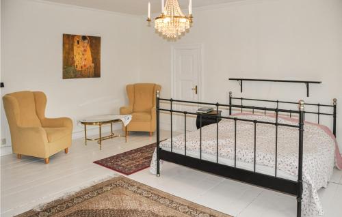 a bedroom with a bed and chairs and a chandelier at Stunning home in Segmon with 5 Bedrooms, Sauna and WiFi in Segmon