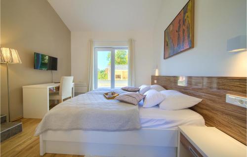 a bedroom with a large white bed with pillows at Amazing Home In Risika With House A Panoramic View in Vrbnik