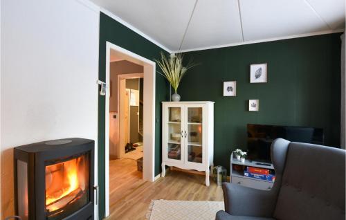 a living room with a fireplace and green walls at Ambjörby in Stöllet