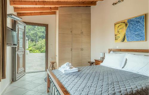 a bedroom with a bed and a sliding glass door at Stunning Home In Kokari With Kitchen in Kokkari