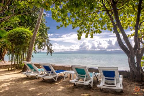 a row of chairs on a beach with the ocean at Sunshine Residence in Baan Tai