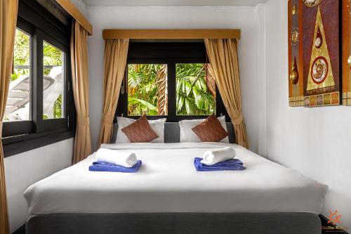 a bedroom with a large bed with blue towels on it at Sunshine Residence in Baan Tai