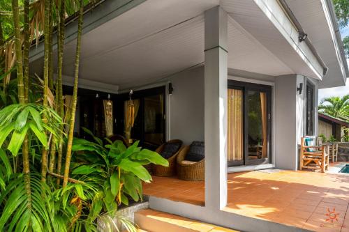 a porch of a house with plants at Sunshine Residence in Baan Tai
