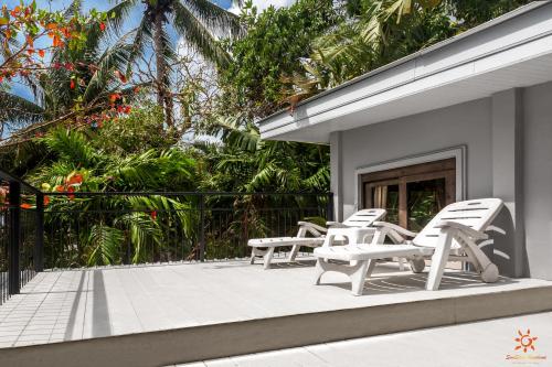 a group of chairs sitting on the front porch of a house at Sunshine Residence in Baan Tai