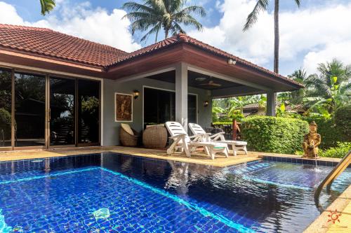 a villa with a swimming pool and a house at Sunshine Residence in Ban Tai