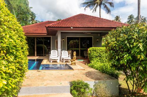 a house with two chairs and a swimming pool at Sunshine Residence in Baan Tai