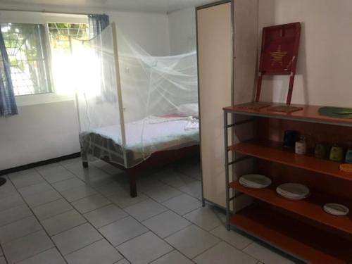 a room with a bed in a room with a window at Unu Pikin Guesthouse in Paramaribo