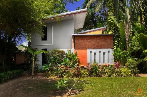 a house with a white fence in a yard at Sunshine Residence in Baan Tai