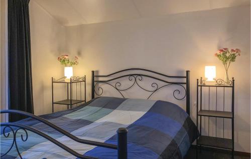 1 dormitorio con 1 cama y 2 jarrones con flores en Buitengoed Het Lageveld - 56 en Hoge-Hexel