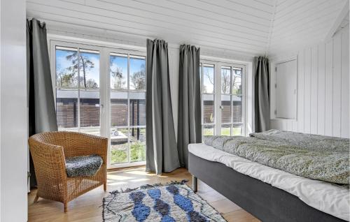 um quarto com uma cama, uma cadeira e janelas em Lovely Home In Hornbk With Kitchen em Hornbæk