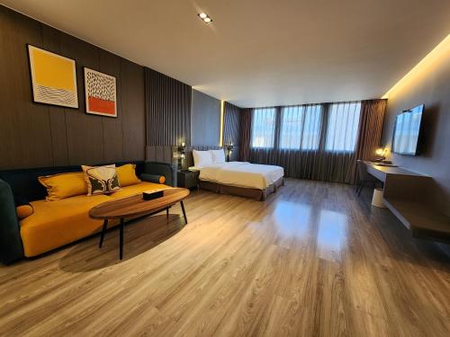 a hotel room with a couch and a bed at Hualien Pink Corner Hotel in Hualien City