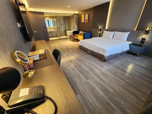 a hotel room with a bed and a desk with a computer at Hualien Pink Corner Hotel in Hualien City