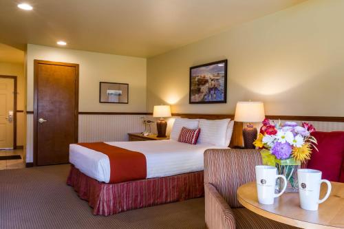 a hotel room with a large bed with flowers on a table at Inn at Cannon Beach in Cannon Beach
