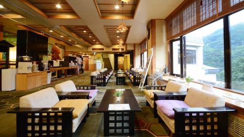 a lobby with couches and tables and large windows at Hotel Manyotei in Nikko