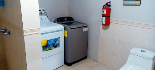 - une petite salle de bains avec une poubelle et un extincteur dans l'établissement Departamento de lujo Mexicali #3, à Mexicali