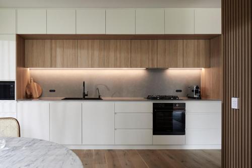 a kitchen with white cabinets and a black oven at Cedars Mount View (Adults Only) in Mount View