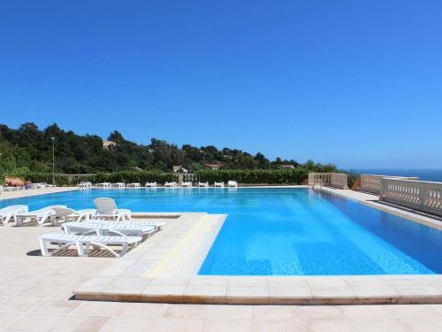 une piscine avec des chaises et l'océan en arrière-plan dans l'établissement 2 pièces cabine avec piscine, tennis, parking - Les Issambres - FR-1-226-389, aux Issambres