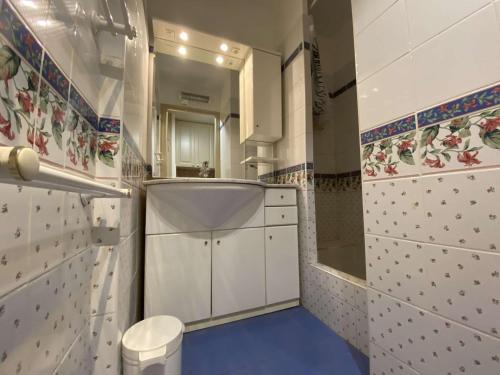 La salle de bains est pourvue d'armoires blanches et d'un sol bleu. dans l'établissement Appartement Sainte-Maxime, 1 pièce, 2 personnes - FR-1-226-444, à Sainte-Maxime
