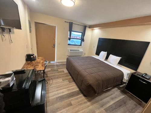 a bedroom with a large bed and a television at Circle Motor Lodge in South Amboy
