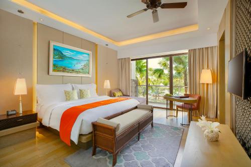 a bedroom with a large bed and a large window at Mövenpick Resort & Spa Jimbaran Bali in Jimbaran