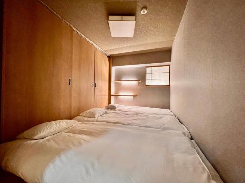 a bedroom with a large white bed in it at 浅草寺3分｜浅草駅6分｜広い｜畳部屋付き｜2-14人｜成田&羽田空港直通 in Tokyo