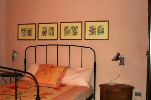1 dormitorio con 1 cama y 4 cuadros en la pared en Camere In Centro, en Agropoli