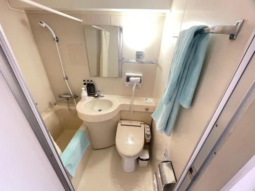 małą łazienkę z toaletą i umywalką w obiekcie Olympic Inn Azabu w Tokio