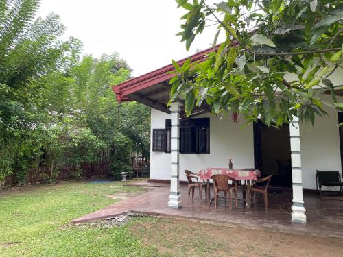 a small white house with a table and chairs at Mahiru Homestay in Weligama