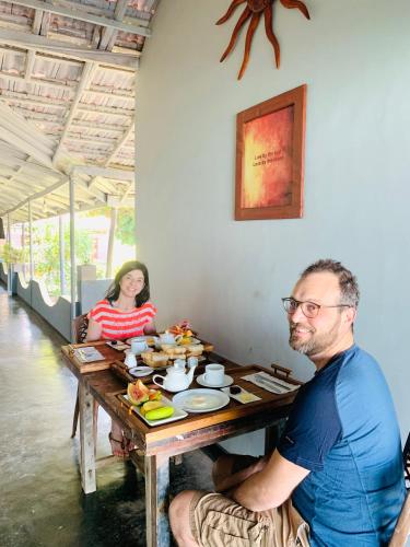 a man sitting at a table in a restaurant at Sun Shine Guest House in Negombo