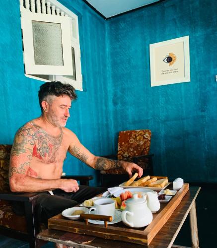 a man sitting at a table with a tray of food at Sun Shine Guest House in Negombo