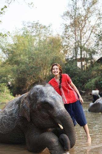 a woman standing on top of an elephant in the water at S.House168 in Chiang Mai