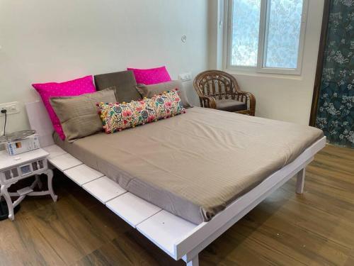 Cette chambre comprend un grand lit avec des oreillers roses. dans l'établissement Lush Green Workation Villa - 1 Bedroom, à Lucknow