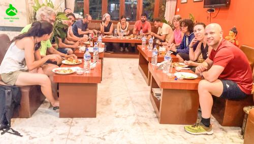 a group of people sitting at tables in a restaurant at Hotel Pomelo House Inn in Kathmandu
