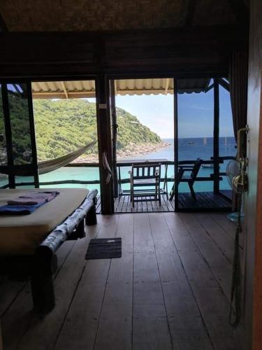a room with a view of the ocean from a house at Chabalay Resort in Koh Tao