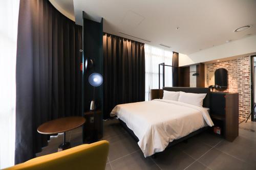 a bedroom with a bed and a table and a chair at LE SEOUL HOTEL in Seoul