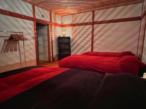 1 Schlafzimmer mit 2 roten Betten in einem Zimmer in der Unterkunft AnYa Ski in & Ski out at Pippu Hokkaido Max 6 ppl in Pippu