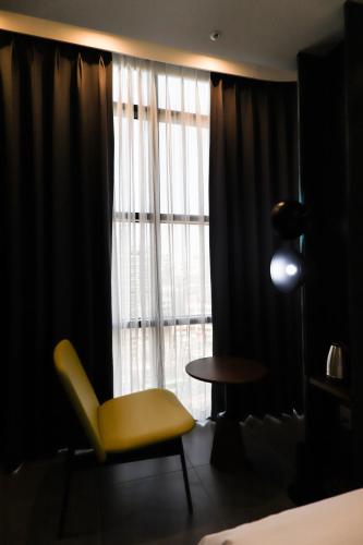 a yellow chair sitting in front of a window at LE SEOUL HOTEL in Seoul