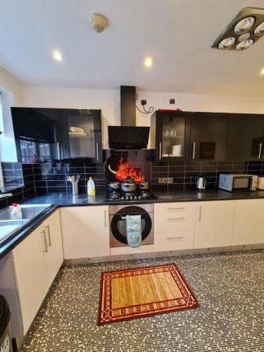 a kitchen with a stove and a fire in it at JAh LODGE BRSITOL BIG HOUSE FREE PARKING 20 PERCENT OFF WEEKLY MONTHLY STAY BUSINESS CONTRACTOR STUDENTS RELOCATIONS 5BED in Bristol